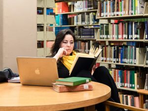 Adult female student reading in college library